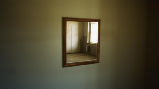 a wall mirror reflecting an empty room symbolizing emptiness after breakup