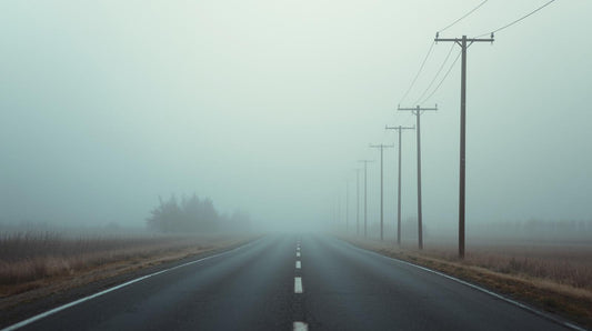 Empty road fading into fog with distant telephone poles, symbolizing uncertainty and overthinking in long-distance relationships.