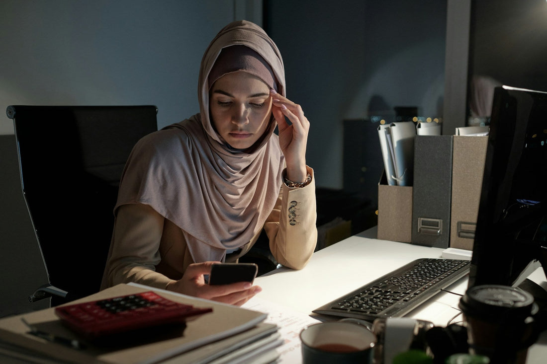 Muslim woman looking anxiously at her phone at night, representing fear that a potential spouse may leave before nikah.
