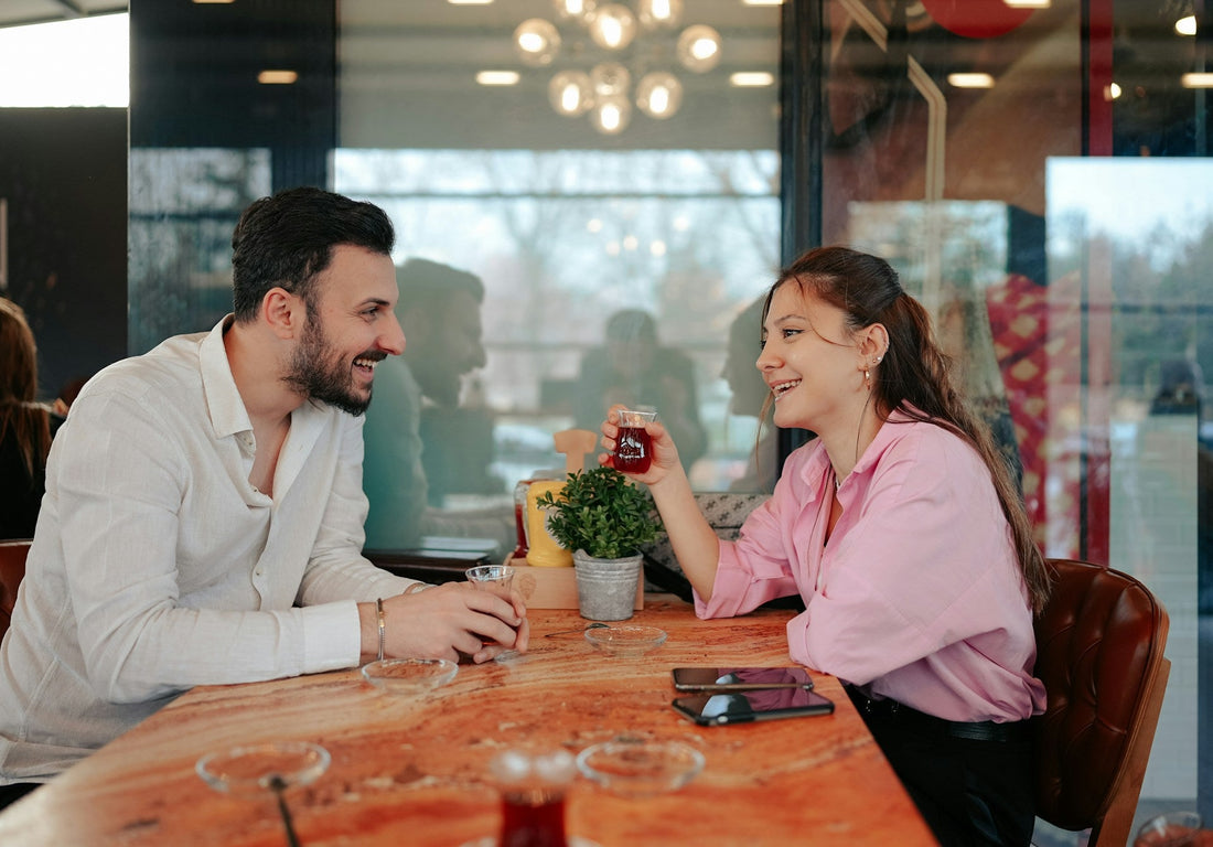 Couple smiling and talking across a café table on a new date, representing learning to trust someone again after heartbreak and opening up to a new relationship.