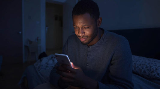 Man sitting on bed at night wondering if his ex is happier with someone new