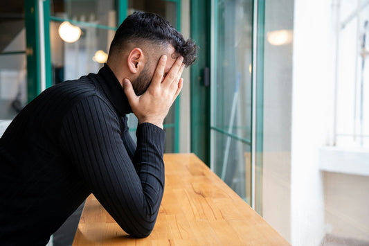 man holding his head concerned about wheter to stay or leave his relationship