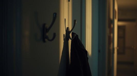 Wall coat hooks with one empty space and one jacket hanging