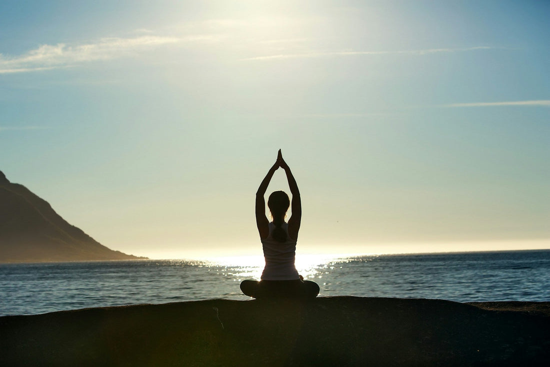 Woman meditating by the sea at sunset, symbolising emotional healing, acceptance and finding peace without closure