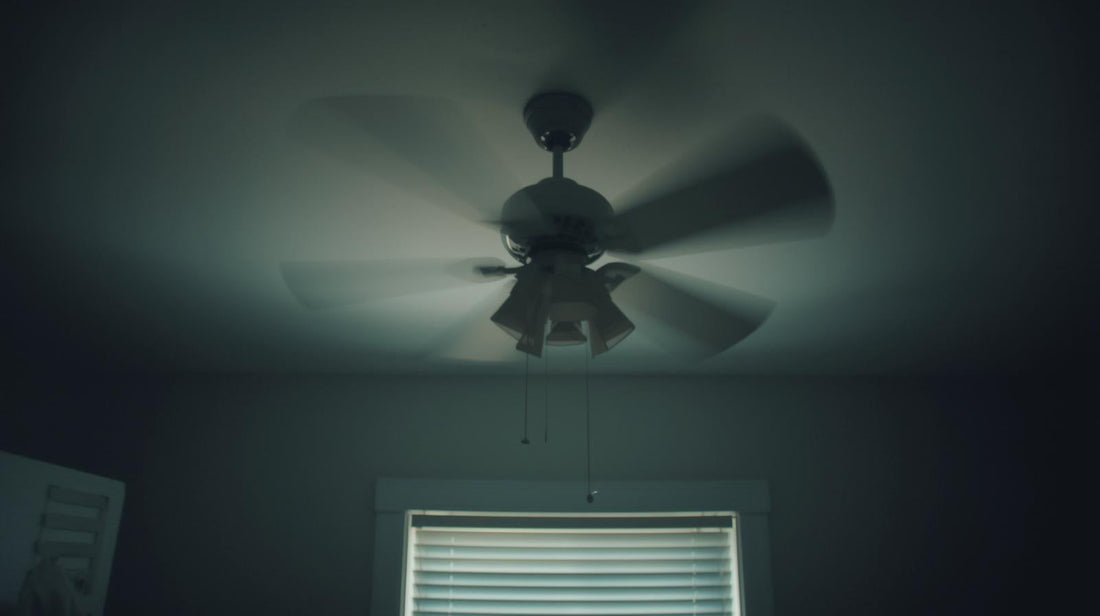 Ceiling fan mid-rotation in soft morning light, symbolizing repetitive thoughts that keep cycling