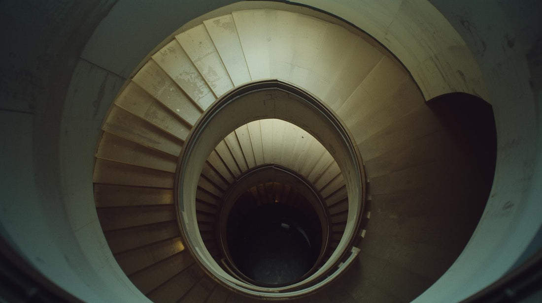 Circular staircase viewed from above in soft natural light, symbolizing repetitive thought patterns and emotional loops
