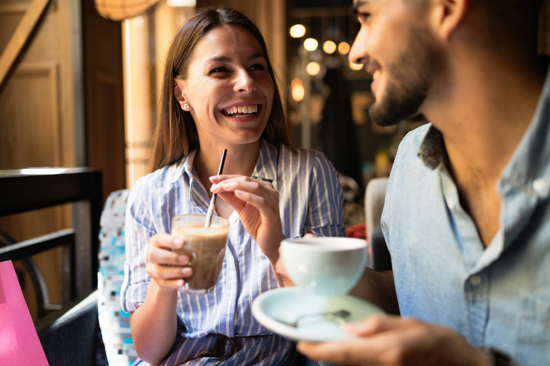 Couple smiling and talking over coffee on a date after divorce, representing starting over, new connections and dating again with confidence.