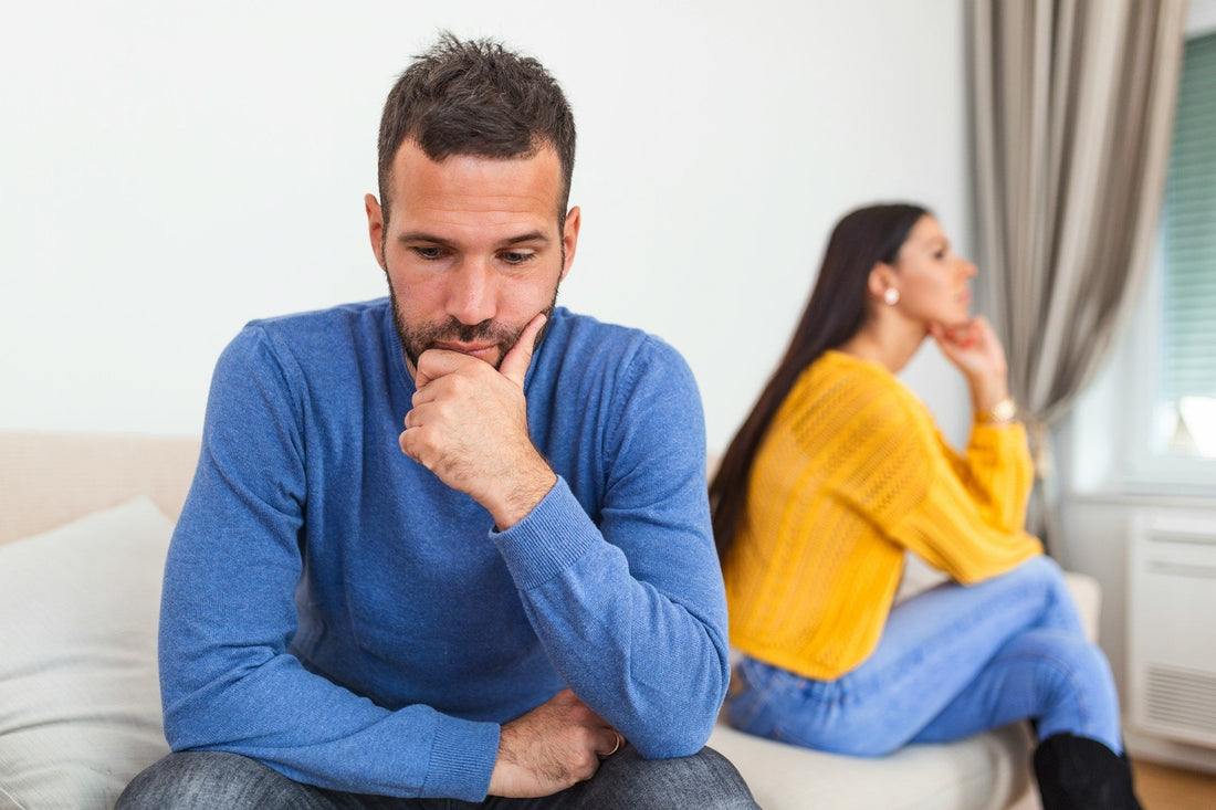 Couple sitting together while one partner appears lost in anxious relationship thoughts