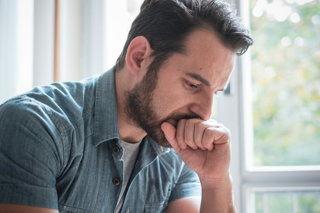Man looking down thoughtfully after a breakup, reflecting on whether avoidant partners regret ending relationships