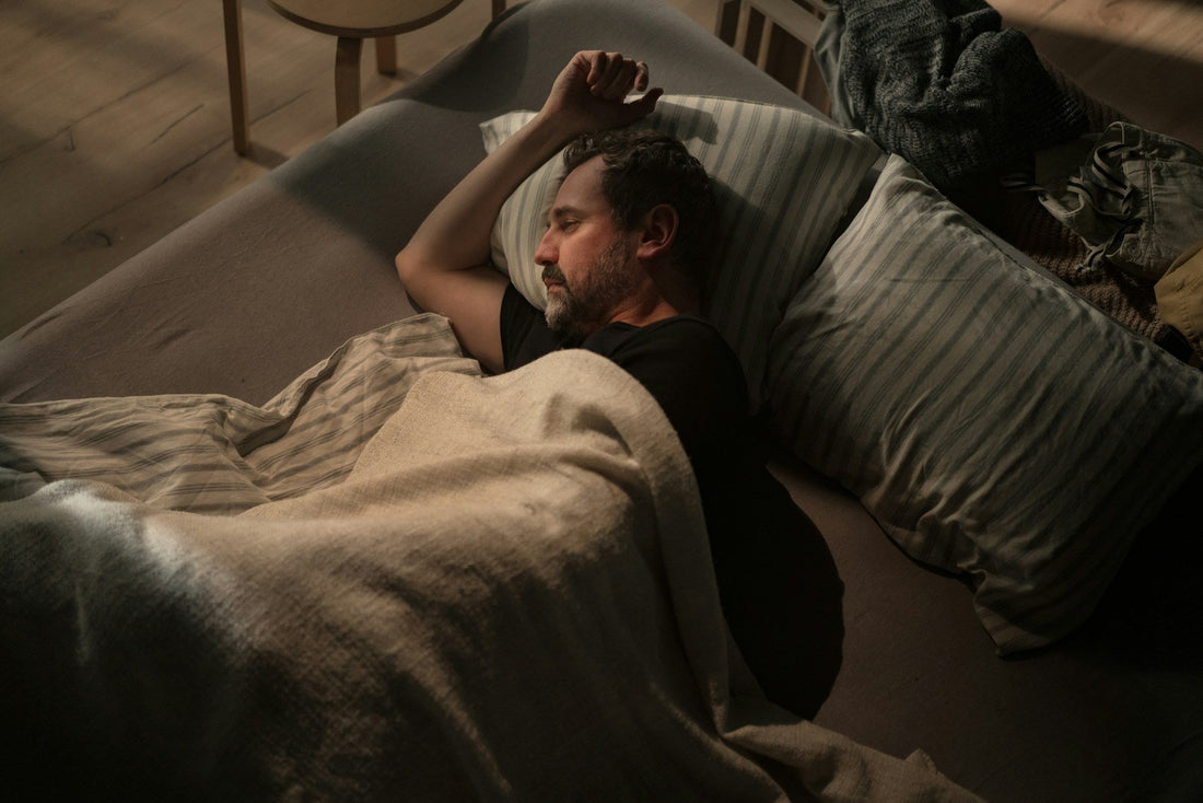 Avoidant man lying awake alone in bed, reflecting on whether he regrets losing a relationship