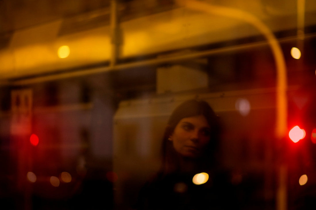 Woman reflected in a dark window at night, symbolizing distance, introspection, and thinking about someone during no contact