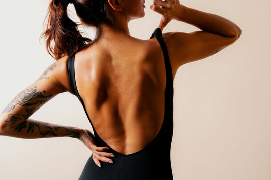 Woman wearing a low-back black outfit, representing reusable silicone nipple covers for backless and braless clothing.