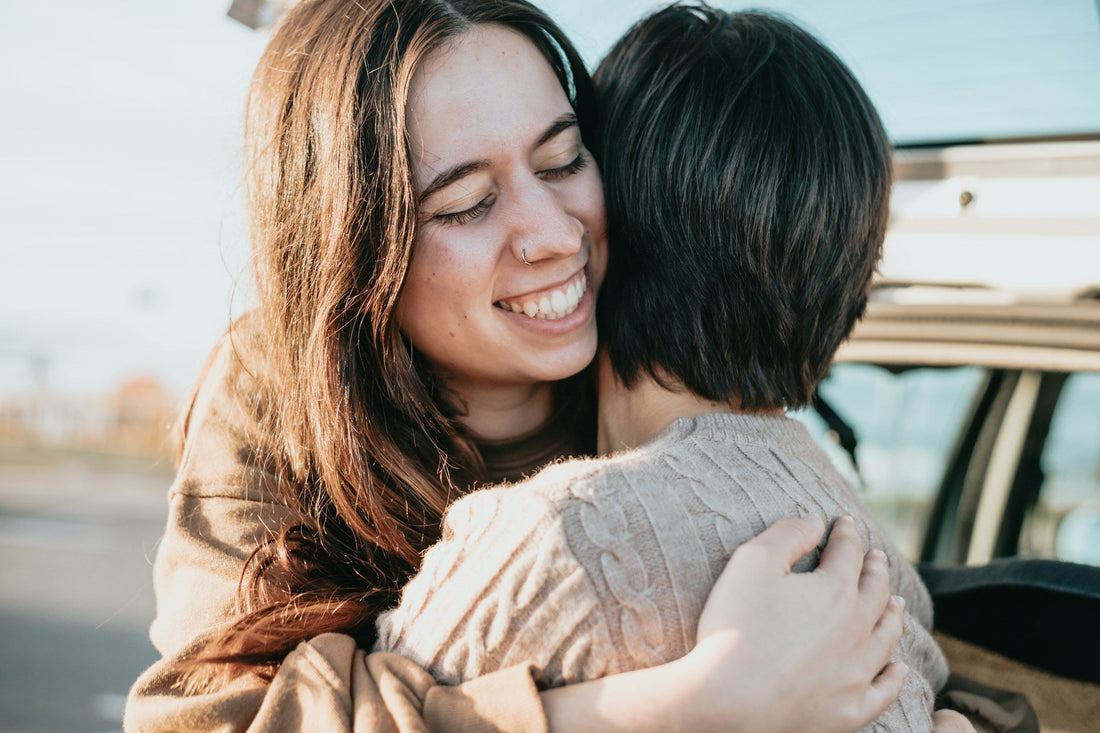 Two people hugging warmly outdoors, symbolising the possibility of staying friends with an ex after a breakup.