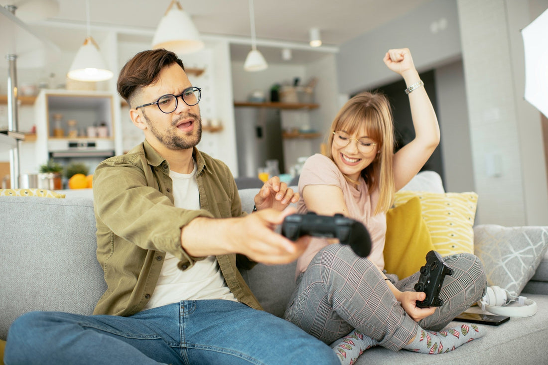 Couple laughing and playing video games together, illustrating fun games and playful connection for long-distance couples.
