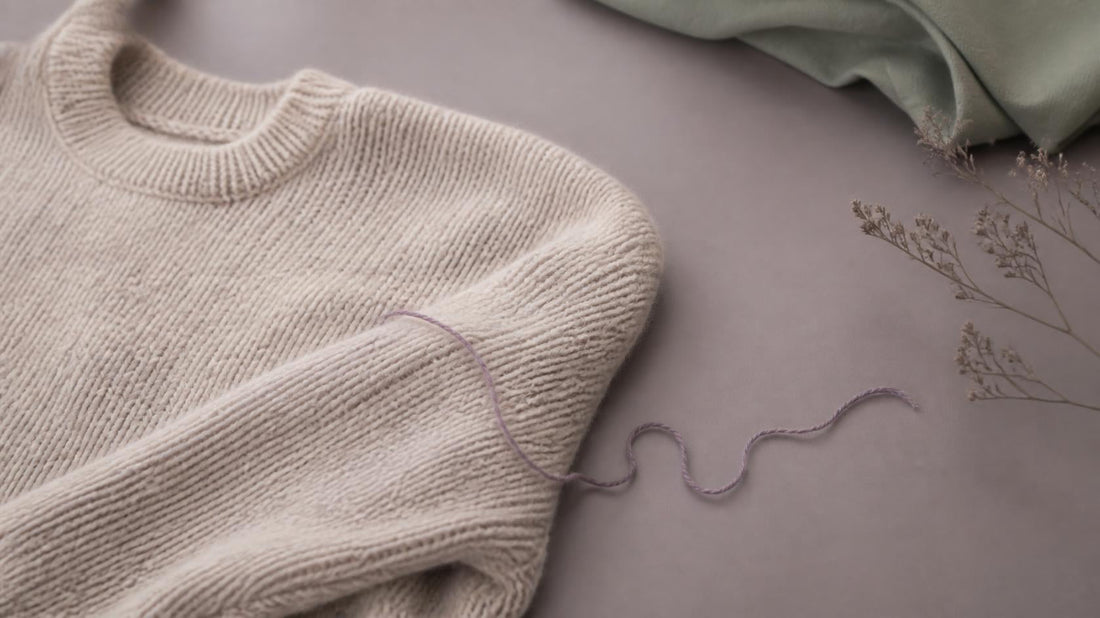 Knitted sweater with a single loose thread symbolizing identity disruption after a gay breakup