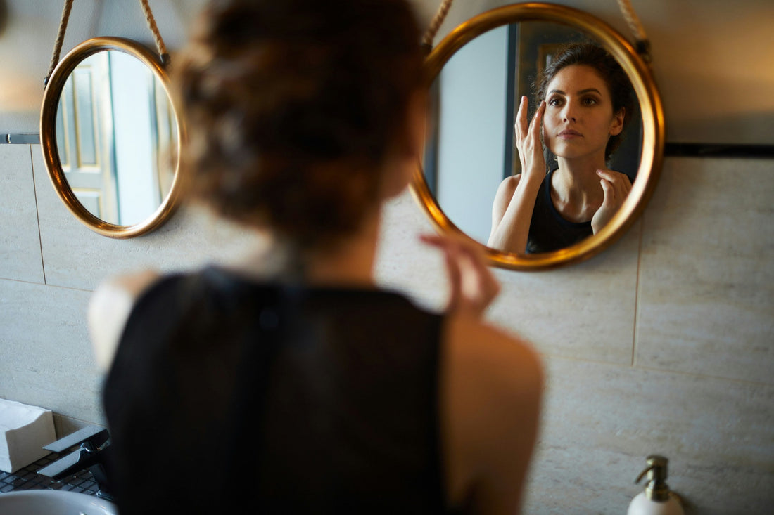 woman looking in mirror trying to reasure herself that she is still sexy after breakup