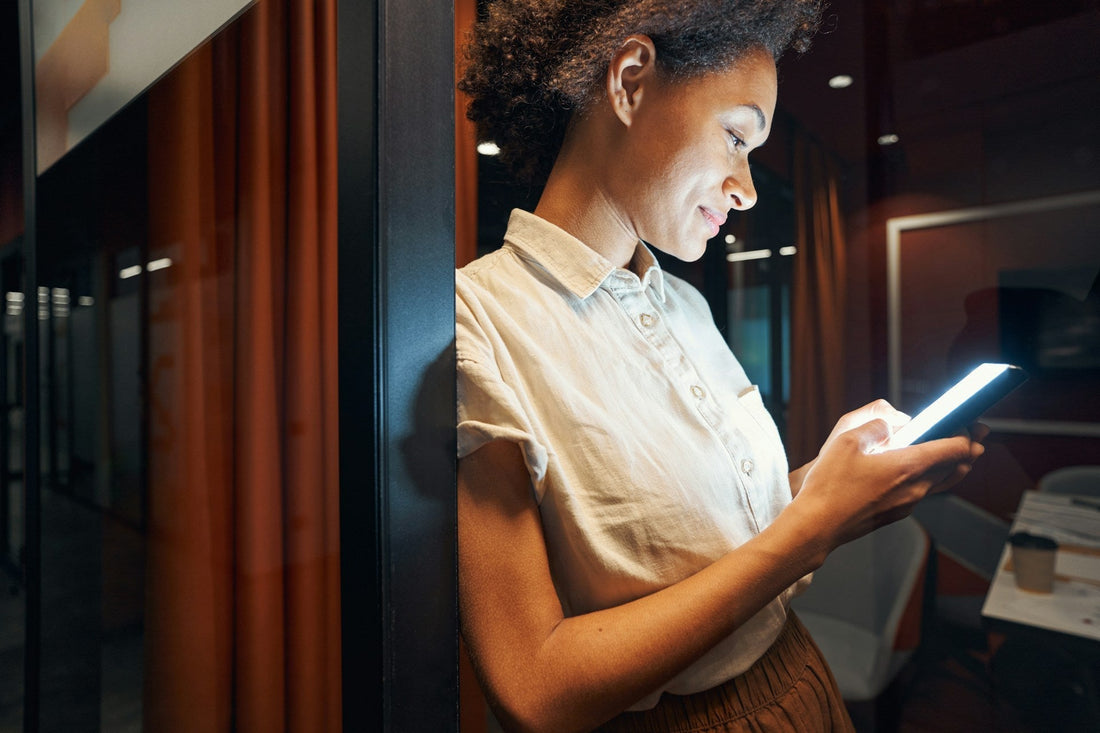 Woman checking her phone after a first date, representing the uncertainty of having a great date but receiving no text afterwards.