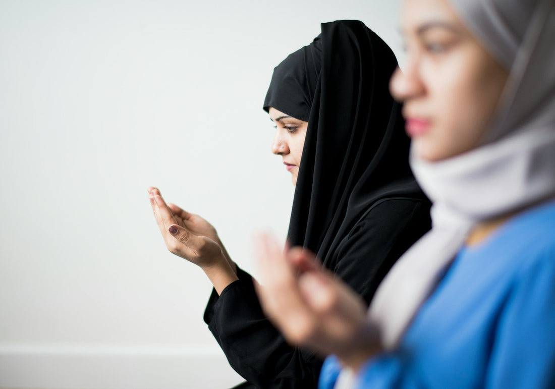 Muslim women raising their hands in dua while seeking faith, comfort and emotional healing after a haram relationship or broken engagement.