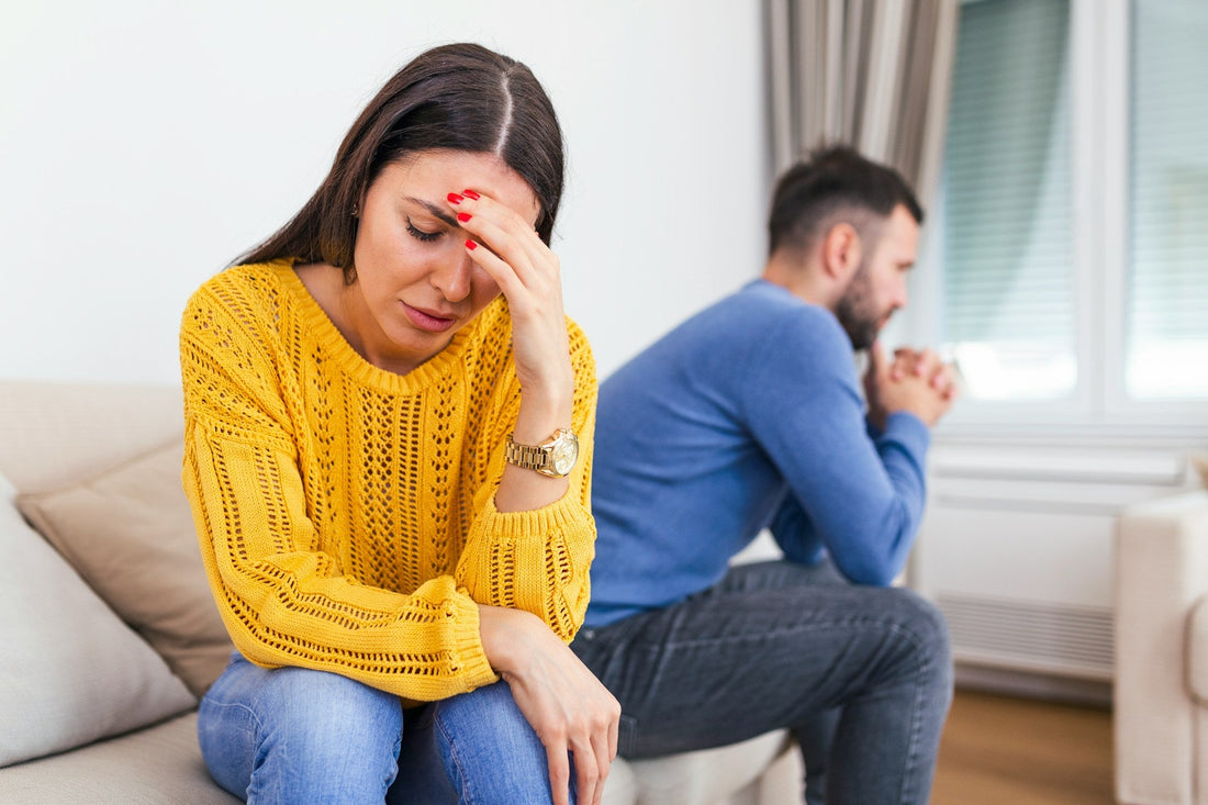 Couple sitting apart after conflict, showing emotional strain and communication problems linked to ADHD in relationships.