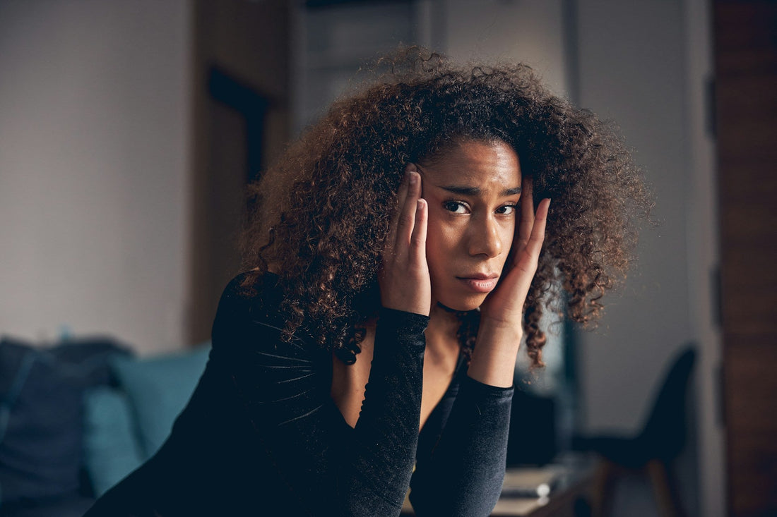 Worried woman sitting alone and questioning whether changes in her boyfriend's behaviour could mean he is cheating