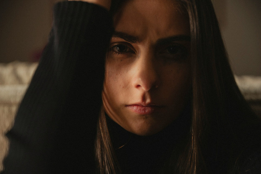 Woman standing with controlled anger, holding in feelings of revenge after a breakup.