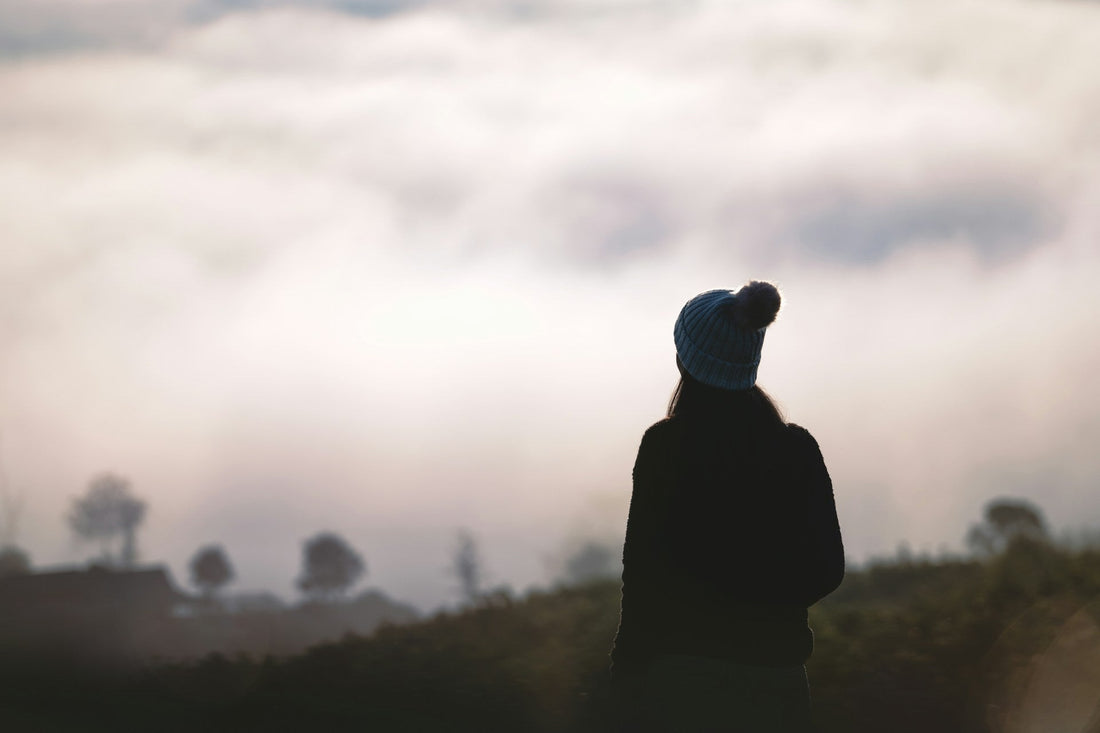 Person standing alone outdoors at dusk while deciding whether to let go of someone