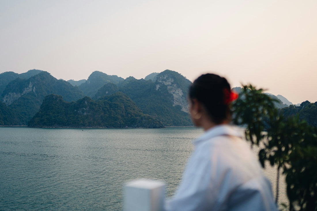 Person looking across a calm lake toward distant mountains while reflecting on letting go of anger