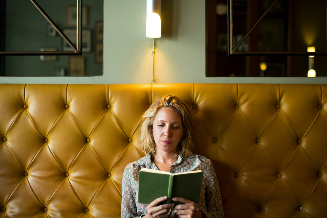 Blond woman reading a book trying to spend her time without being lonely