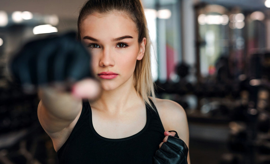 Woman training with boxing gloves in a gym, symbolising confidence, self-respect, and personal growth while trying to win an ex back.