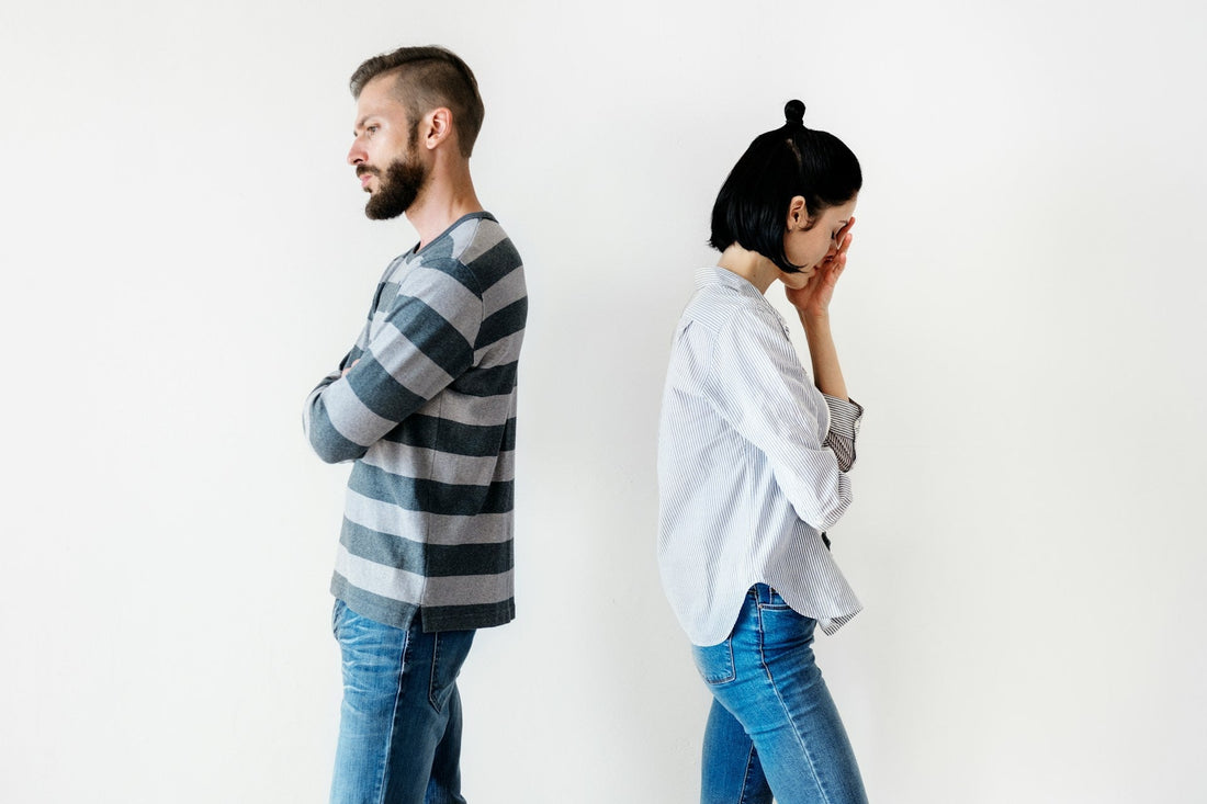 Couple standing back to back with one person looking upset, representing emotional distance and uncertainty about relationship readiness