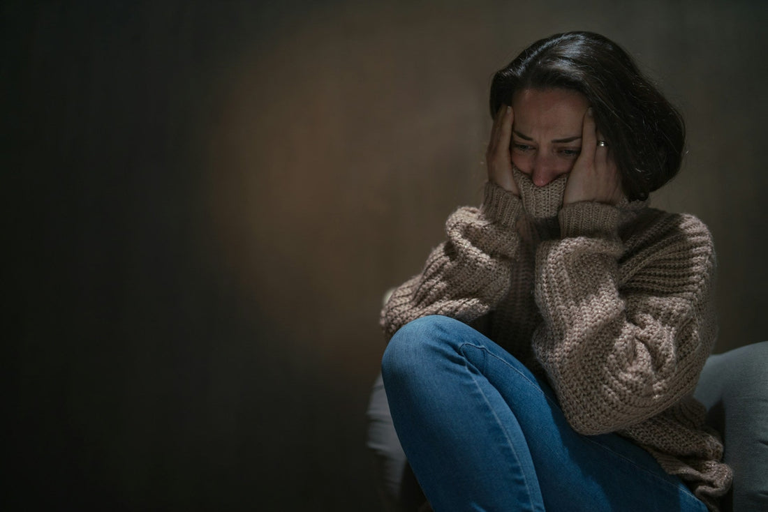 Distressed woman sitting alone and questioning whether her partner's close connection with someone else is emotional cheating