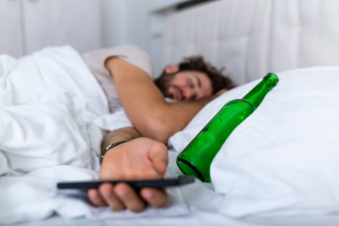Man asleep in bed beside an empty alcohol bottle, suggesting signs of a husband’s drinking problem and alcohol affecting marriage