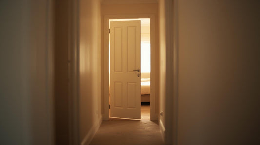 Partially closed bedroom door with light filtering through symbolizing suspicion and emotional uncertainty