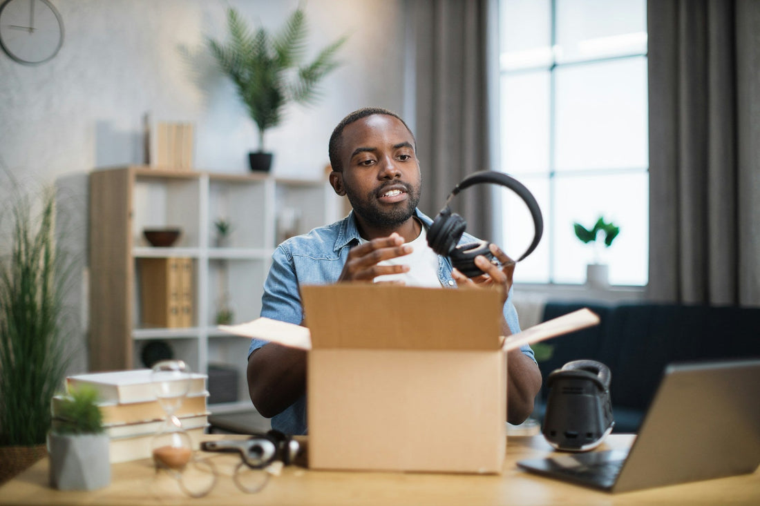 Man opening headphones from a gift box sent by his long-distance partner
