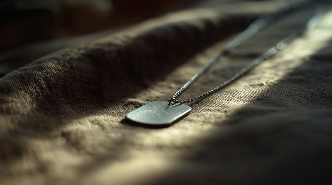 Subtle dog tag necklace resting on folded neutral fabric symbolizing steady connection during military separation