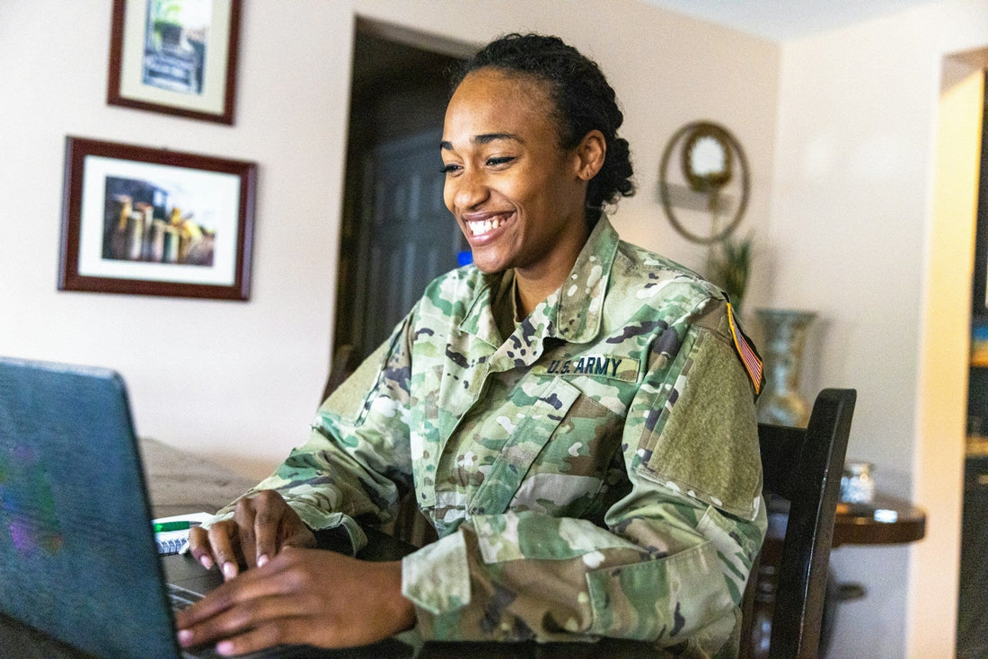 Woman in military uniform smiling during a video call with her long-distance partner.