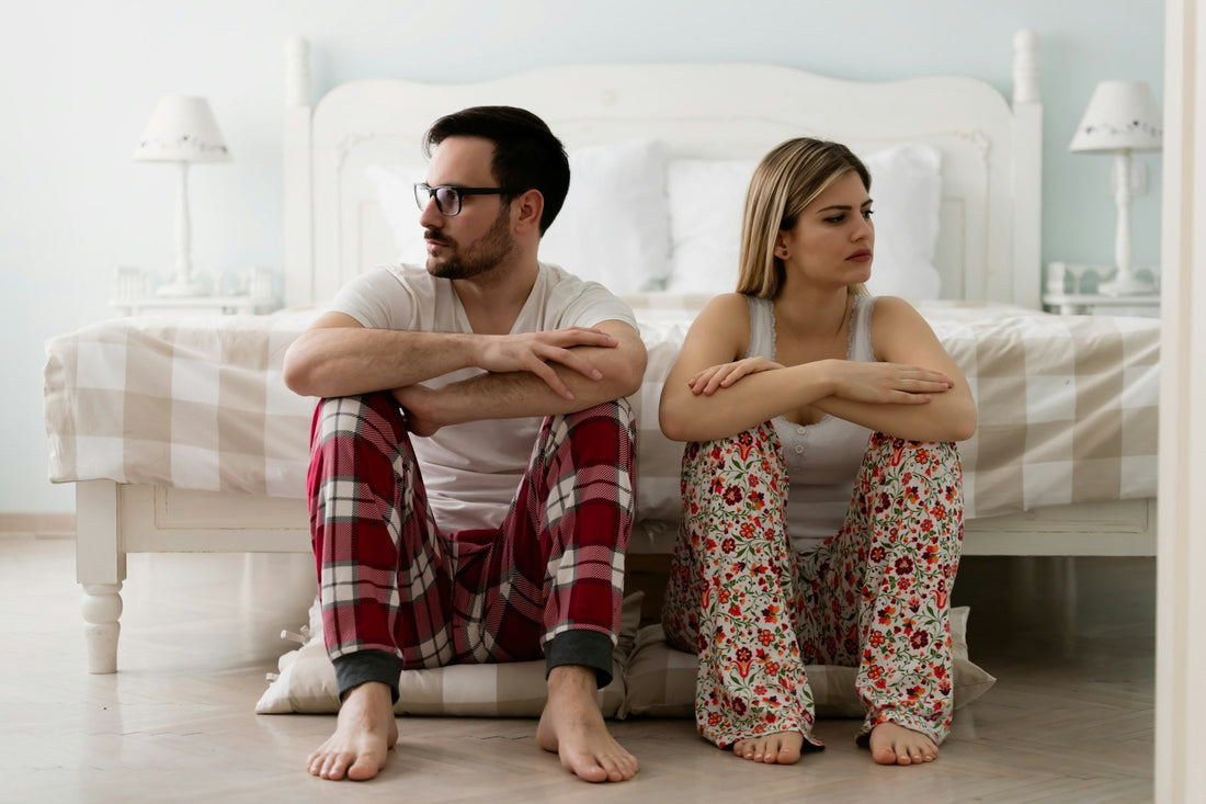 Couple sitting apart and looking away from each other after an argument, illustrating frequent conflict in a long-distance relationship.
