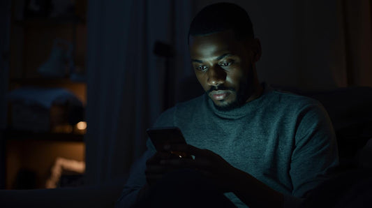 person sitting alone looking at phone feeling lonely in a long distance relationship