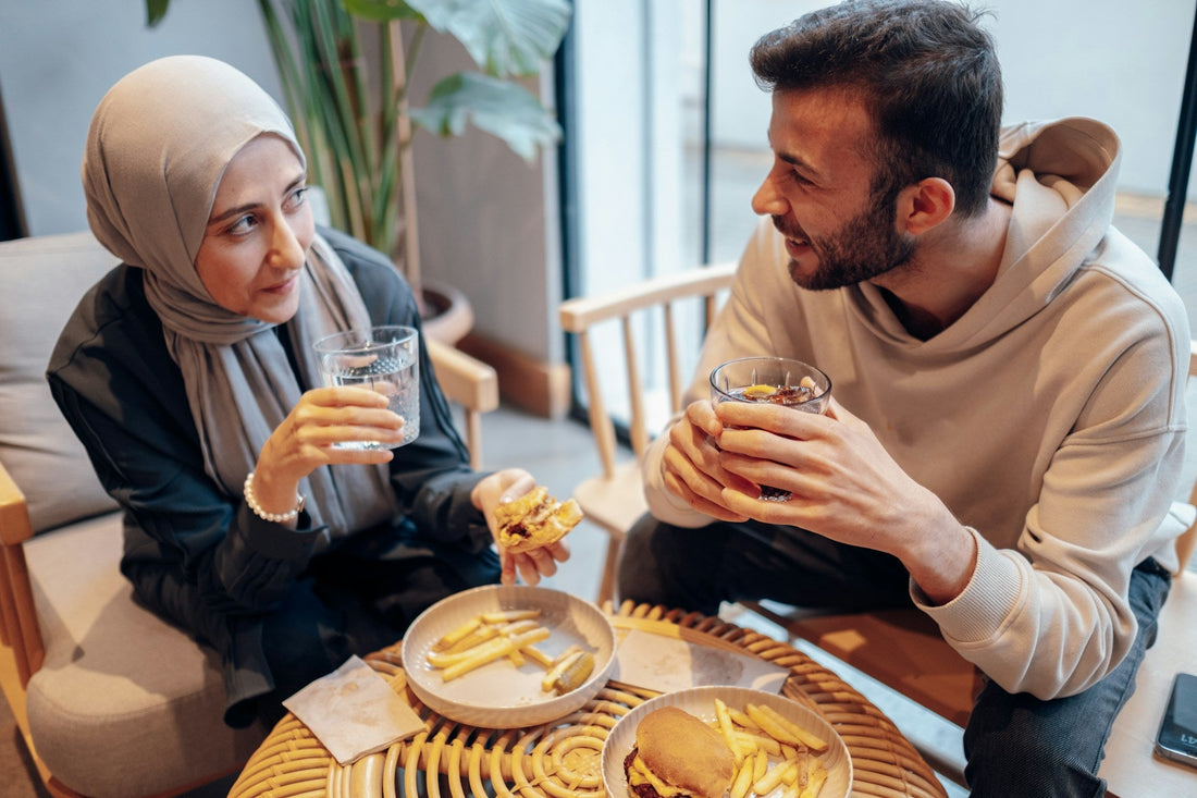 Muslim couple talking over a meal while comparing marriage apps with family introductions as ways to meet a potential spouse.