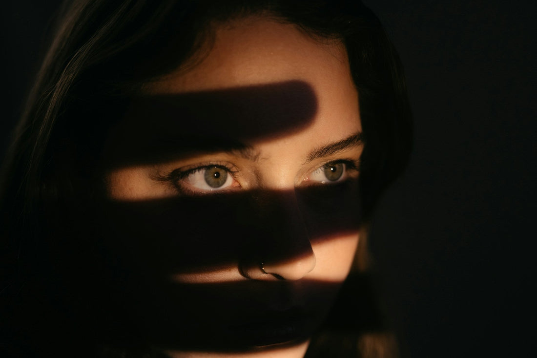 Woman’s face partially obscured by dark shadows, symbolizing fear, confusion, and emotional control in a narcissistic marriage.