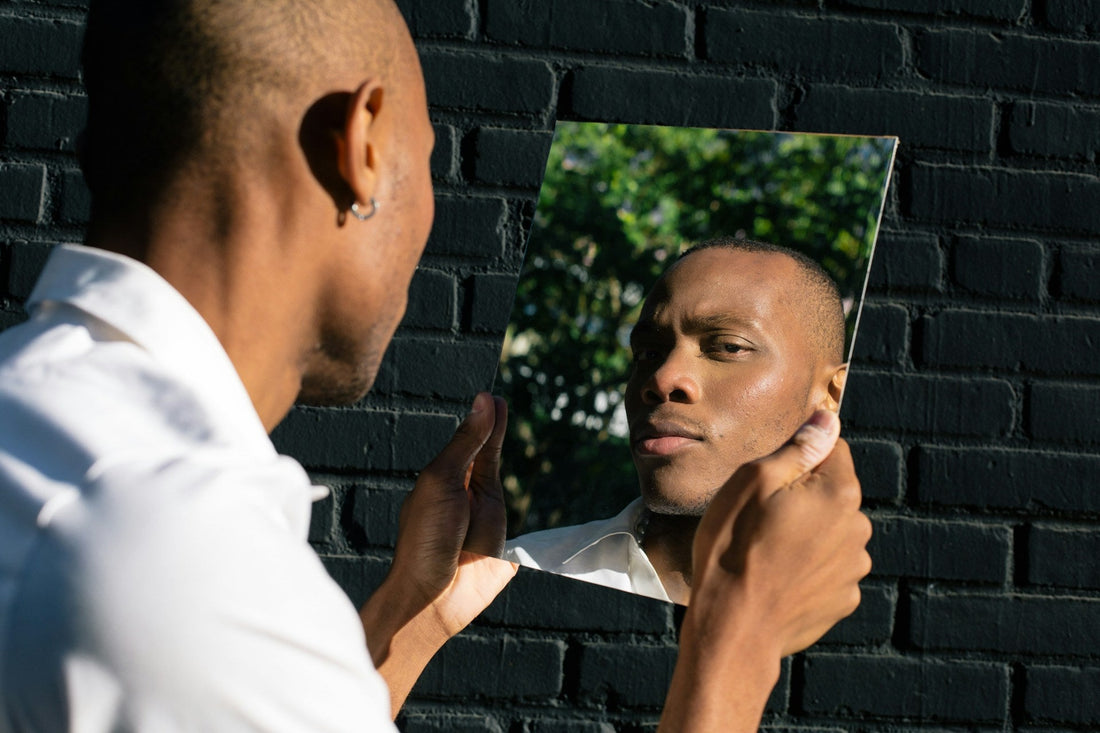 Man examining his reflection in a mirror, symbolizing self-image, identity, and narcissistic patterns within marriage.