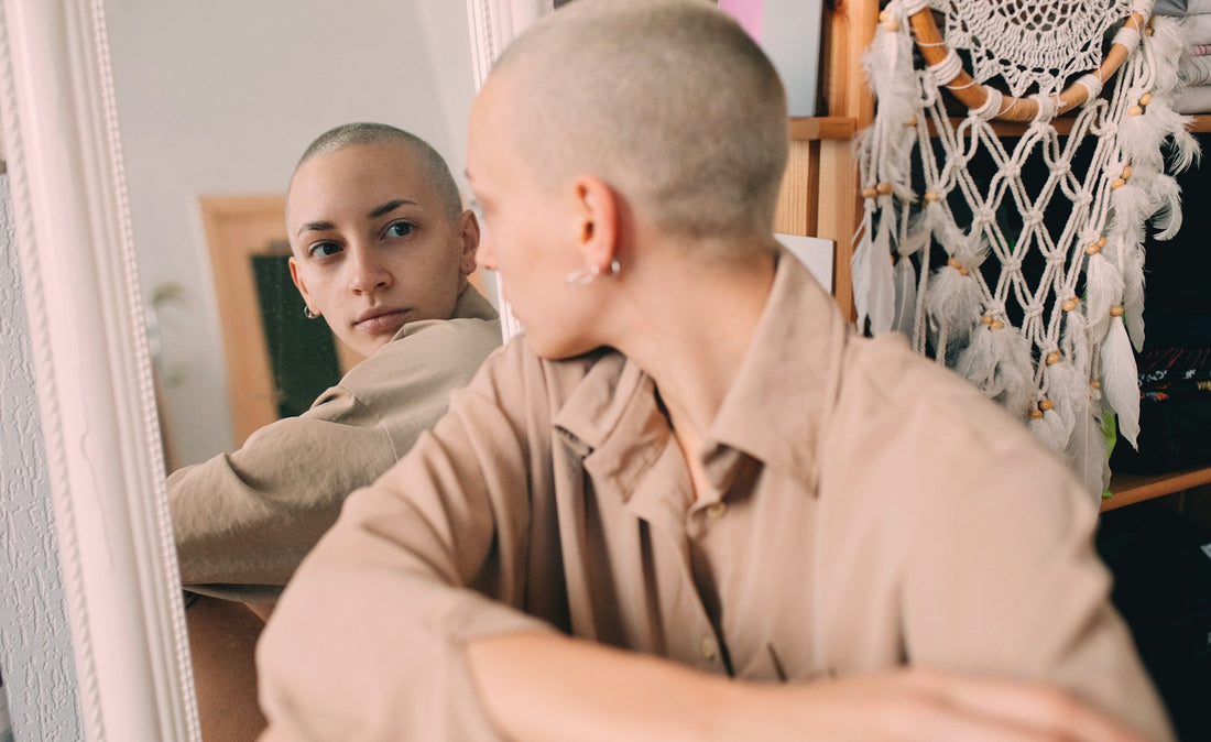 **Alt text:** `Person looking at their reflection in a mirror while questioning their identity and fear of being alone after a breakup`