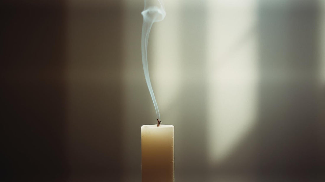Extinguished candle with soft smoke symbolizing quiet acknowledgment of an ending