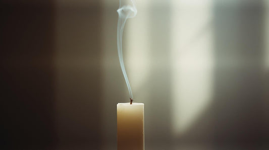 Extinguished candle with soft smoke symbolizing quiet acknowledgment of an ending