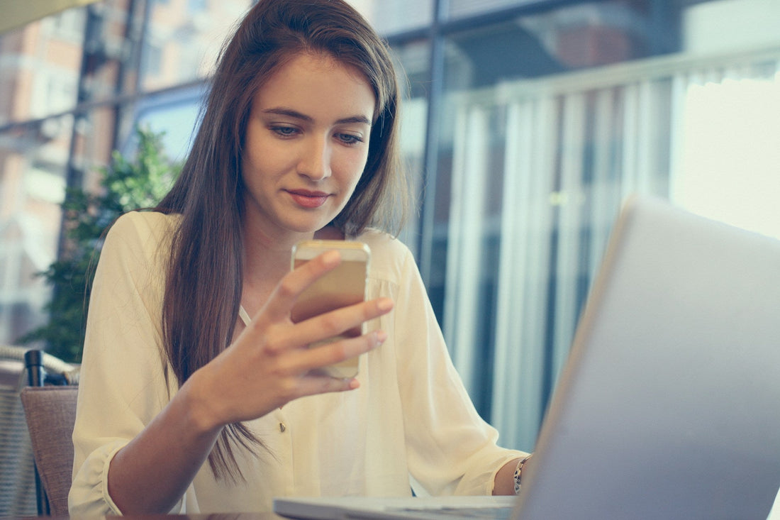 Woman looking at her smartphone while deciding whether to send the first text to someone she is dating.