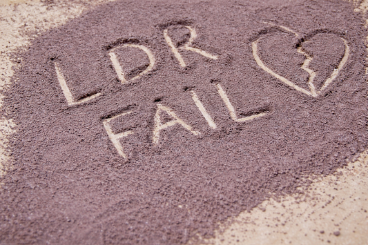 LDR fail written in sand with broken heart symbol representing signs a long distance relationship is failing