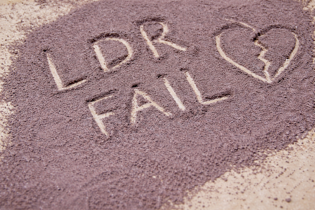 LDR fail written in sand with broken heart symbol representing signs a long distance relationship is failing