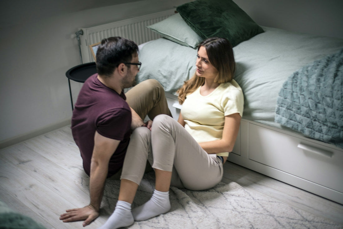 Couple sitting closely together and talking face to face, representing emotional intimacy, trust, vulnerability and feeling safe and understood in a relationship.