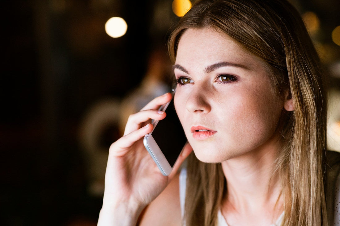 Woman on the phone looking concerned while questioning possible signs her boyfriend is cheating