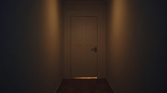 Closed interior door with warm light visible underneath, symbolizing emotional withholding and the silent treatment in a narcissistic relationship